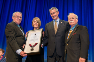 Medal of Honor recipient and Society President Tom Kelley (left) and Medal of Honor recipient Barney Barnum (right) present the Community Service Hero Award to UTR. UTR CEO, Dr. Sally Ann Zoll and UTR Board Chair, Jeff Mader received on behalf of the organization. 