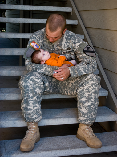 military-dad-holding-baby-on-stairwell